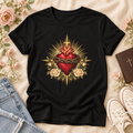 Black Sacred Heart of Jesus T-shirt featuring a red heart, crown of thorns, cross, cream roses, and golden rays.