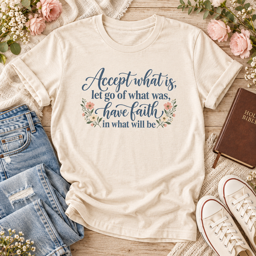 Natural T-shirt reading “Accept what is, let go of what was, have faith in what will be,” in dark blue lettering with floral accents.