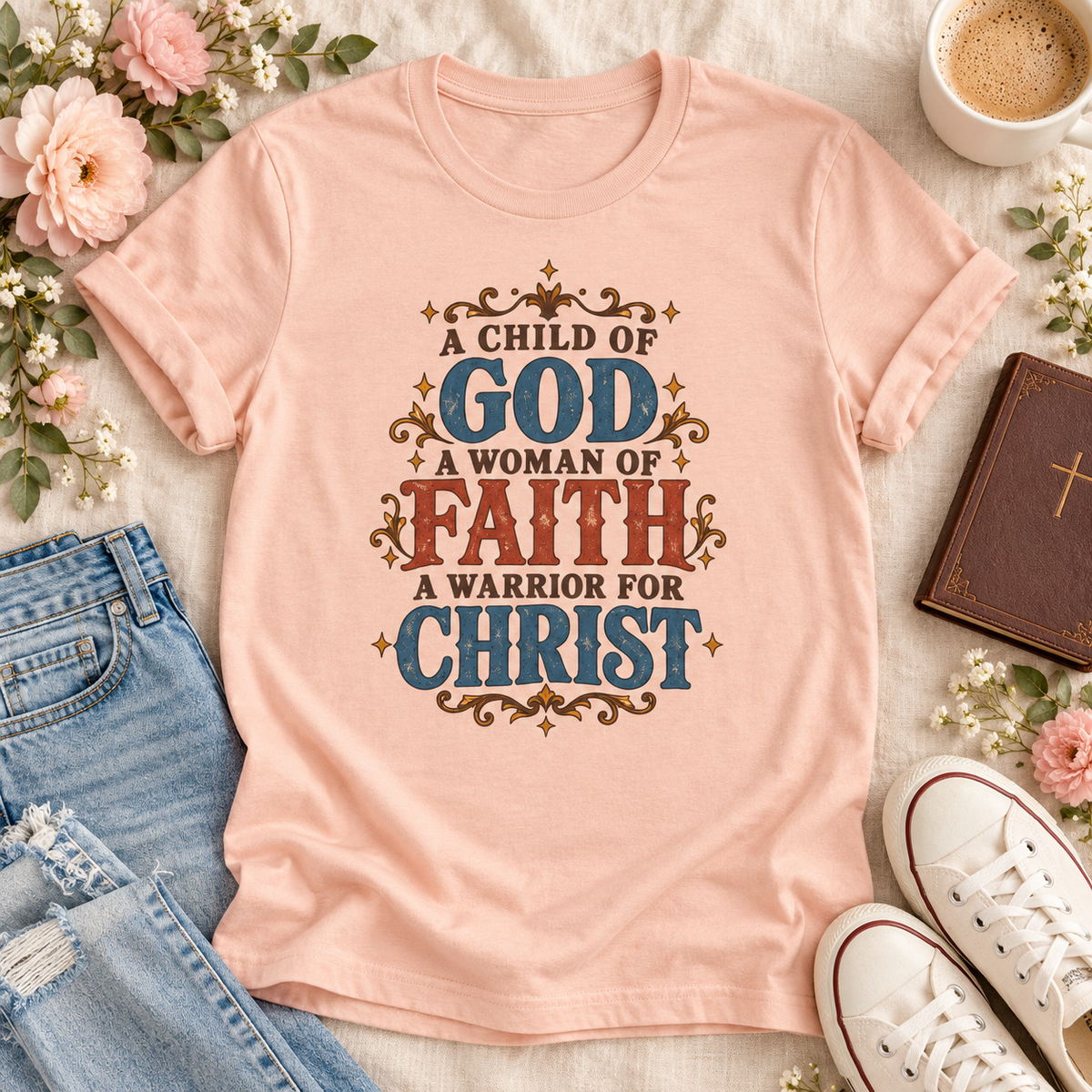 Peach T-shirt reading “A Child of God, A Woman of Faith, A Warrior for Christ,” with blue and rust lettering and golden flourishes.