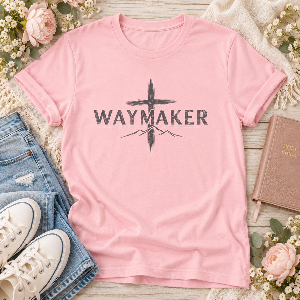 Pink Waymaker Christian T-shirt featuring distressed dark lettering across a brushstroke-style cross with mountain outlines.