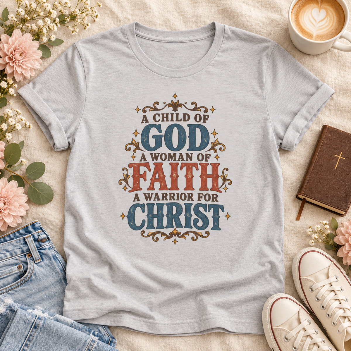 Silver T-shirt reading “A Child of God, A Woman of Faith, A Warrior for Christ,” with blue and rust lettering and golden flourishes.