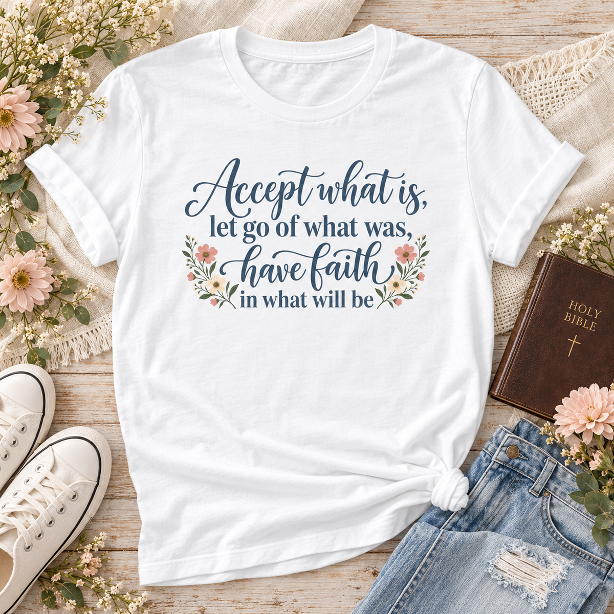 White T-shirt reading “Accept what is, let go of what was, have faith in what will be,” in dark blue lettering with floral accents.